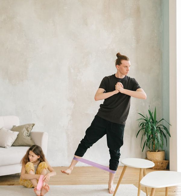Man stretching in a bright, modern living room at sunrise.